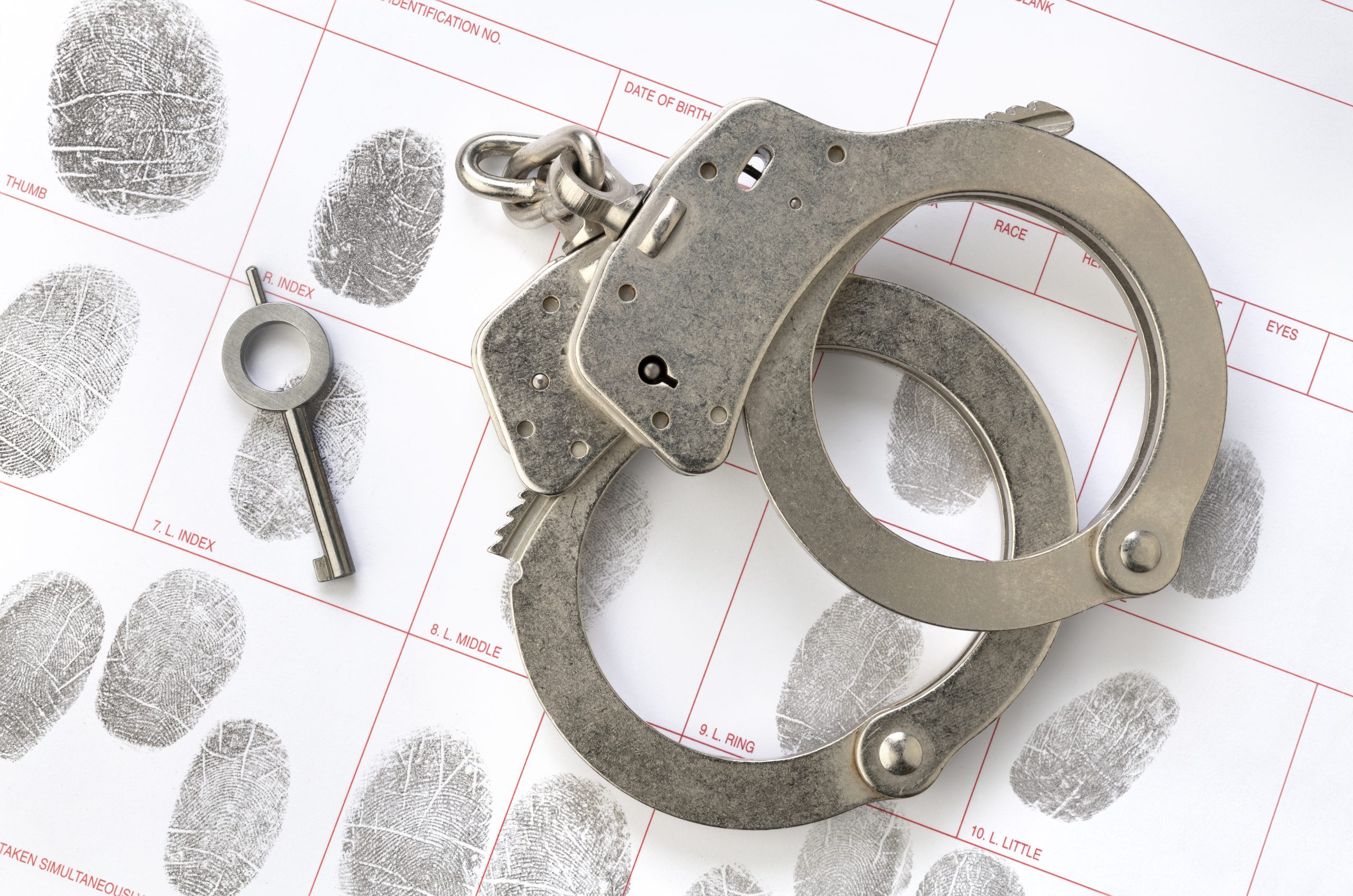 Handcuffs and fingerprint sheet representing criminal defense